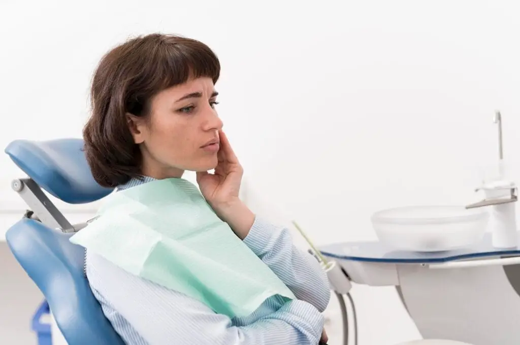 A woman sitting on a dentist chair for dental implants treatment with gum disease.