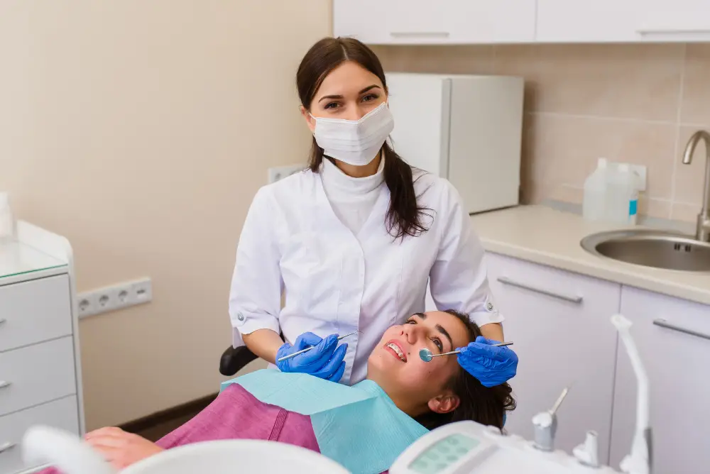 Dental hygienist performing a periodontal maintenance cleaning while examining a patient's gums during a routine visit.