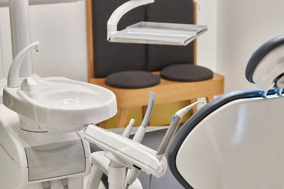 Modern dental treatment room with dental chair, overhead light, and examination equipment.