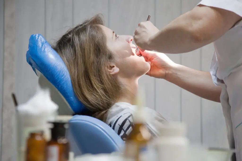 Dentist examining a patient during dental treatment for bone grafting after tooth extraction in Brandywine
