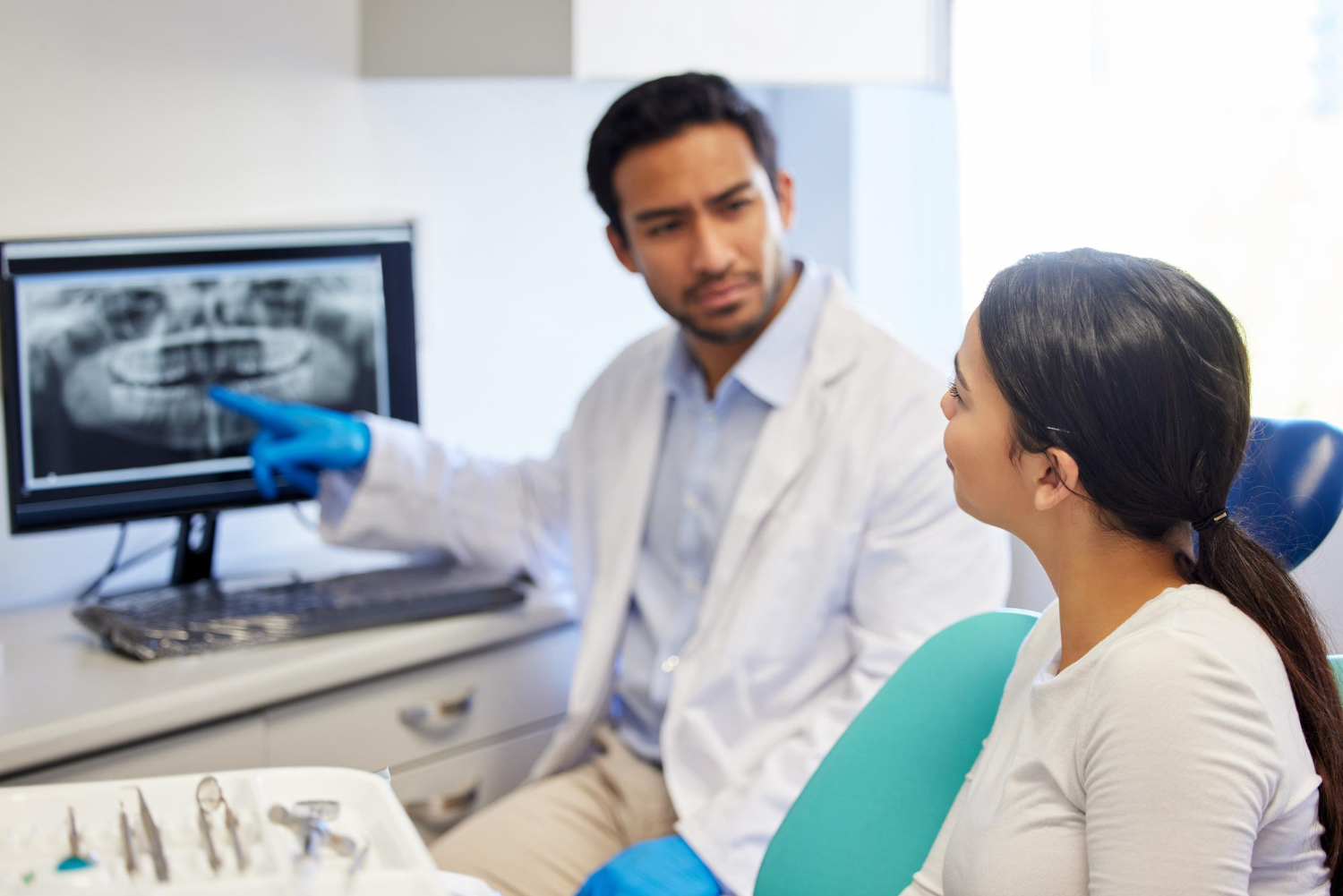 Dentist explaining a dental X-ray to a patient during a consultation.