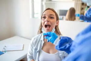 Periodontist examining a patient during an oral biopsy in Brandywine, MD for evaluation of suspicious mouth lesion site.