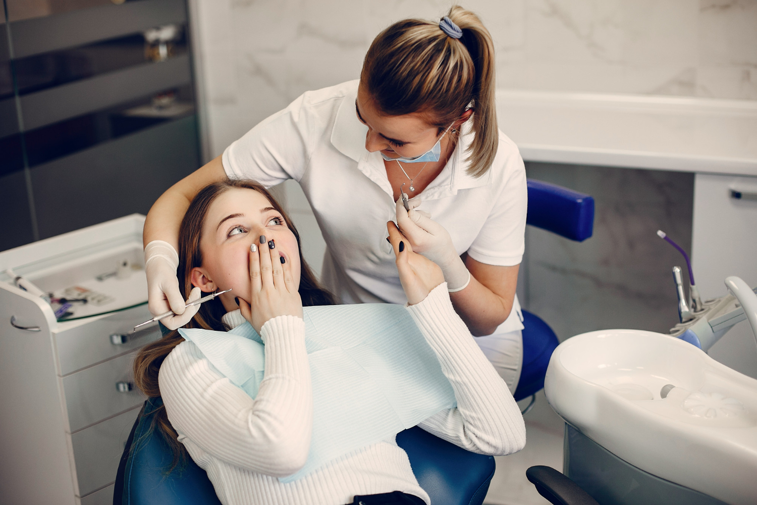 Dentist examining a patient during a dental treatment appointment in a modern clinic.