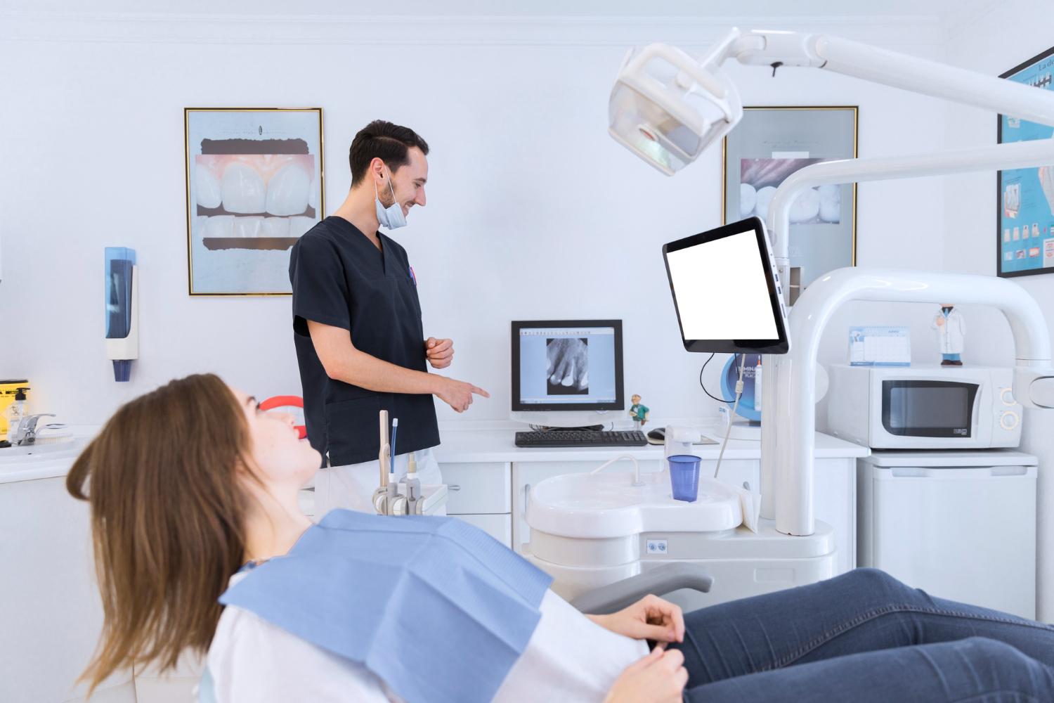 A dentist explaining dental X-ray findings to a patient during a consultation in a modern dental clinic.