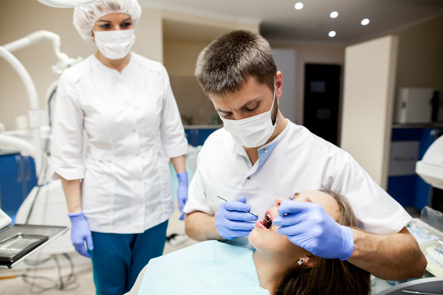 Dentist performing deep cleaning and periodontal treatment on a patient in a dental clinic setting.
