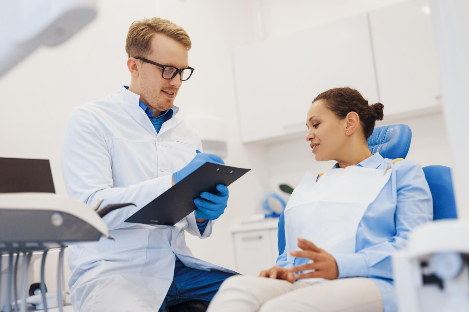 Dentist discussing post-treatment care and follow-up instructions with a patient after periodontal treatment.
