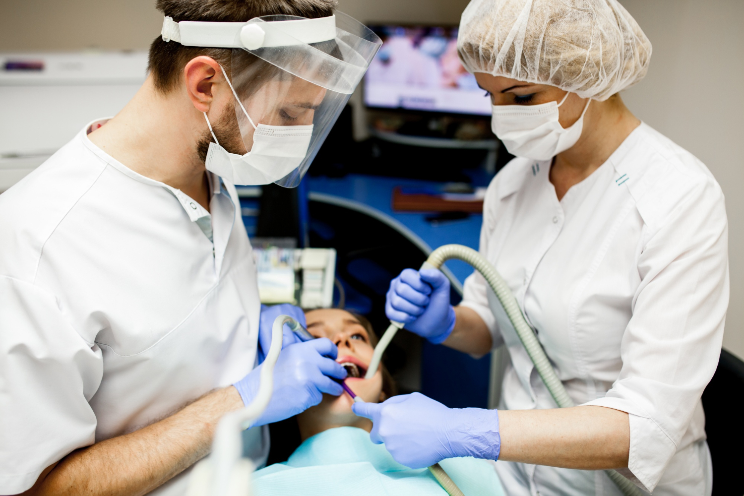 Dentists examining a patient's mouth during oral biopsies in Brandywine, MD for evaluation of a suspicious oral lesion.